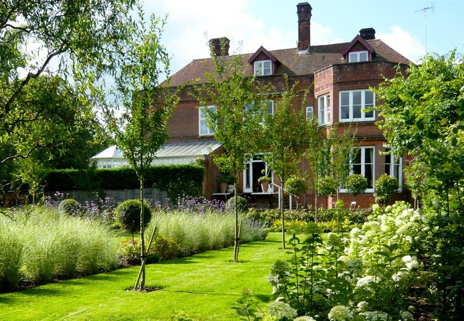 This was our garden before we added the glass box extension & raised terrace. I've used miscanthus morning light with topiary pompoms & hydrangea limelight all down the boundary for drama