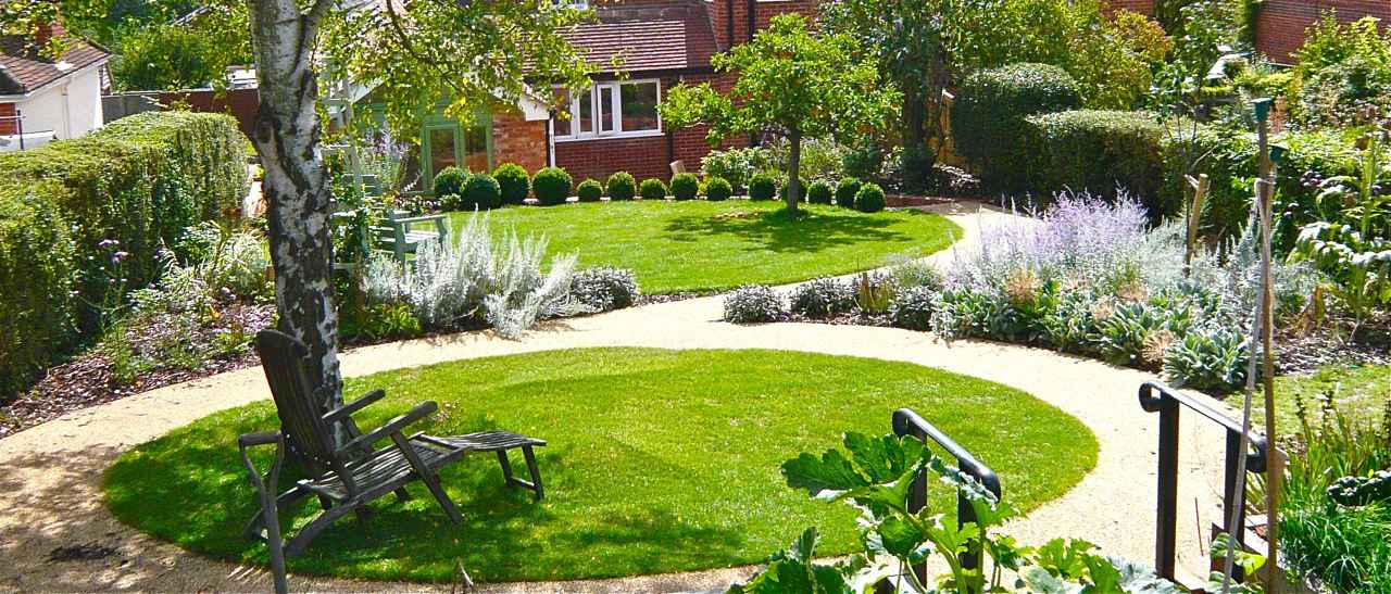 This is a garden design using circles as a theme. two interlinking circular lawns with mediterranean planting & bound gravel paths