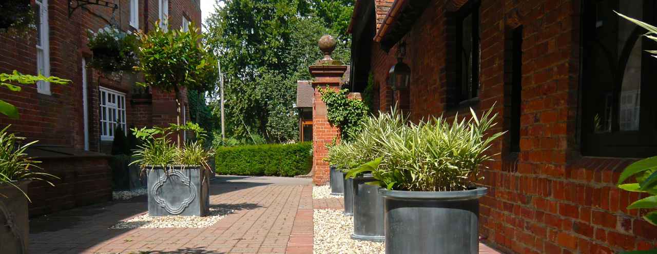 Here we revamped a Victorian courtyard that was once the tradesman entrance. Now a smart courtyard with evergreen topiary & lead style planters