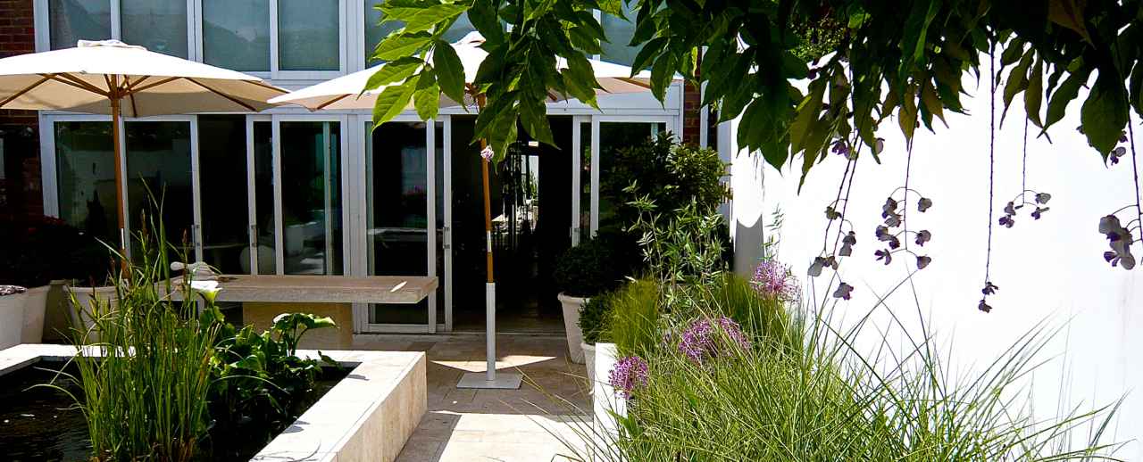 This garden in Henley on thames s a simple & modern courtyard with raised beds & pool with pretty planting. A perfect lock up & leave for my clients