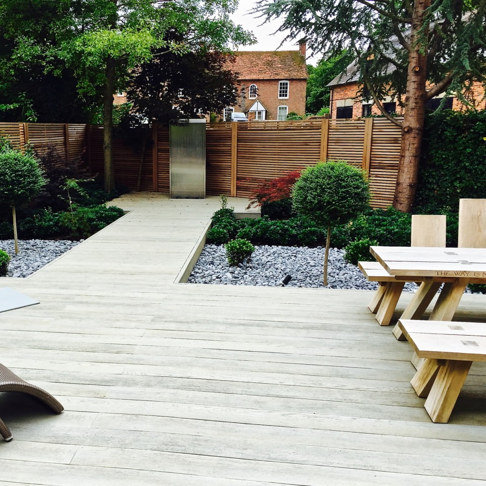 Lovely boardwalk & water feature with topiary in this modern garden