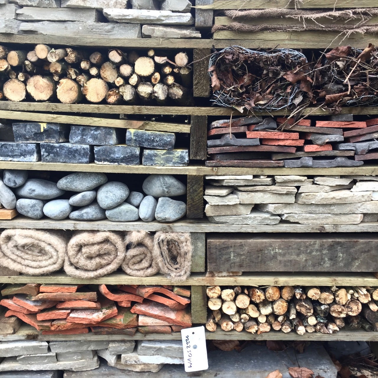 This is a bug hotel made by The Garden Design Co Ltd for a woodland garden out of recycled pallets