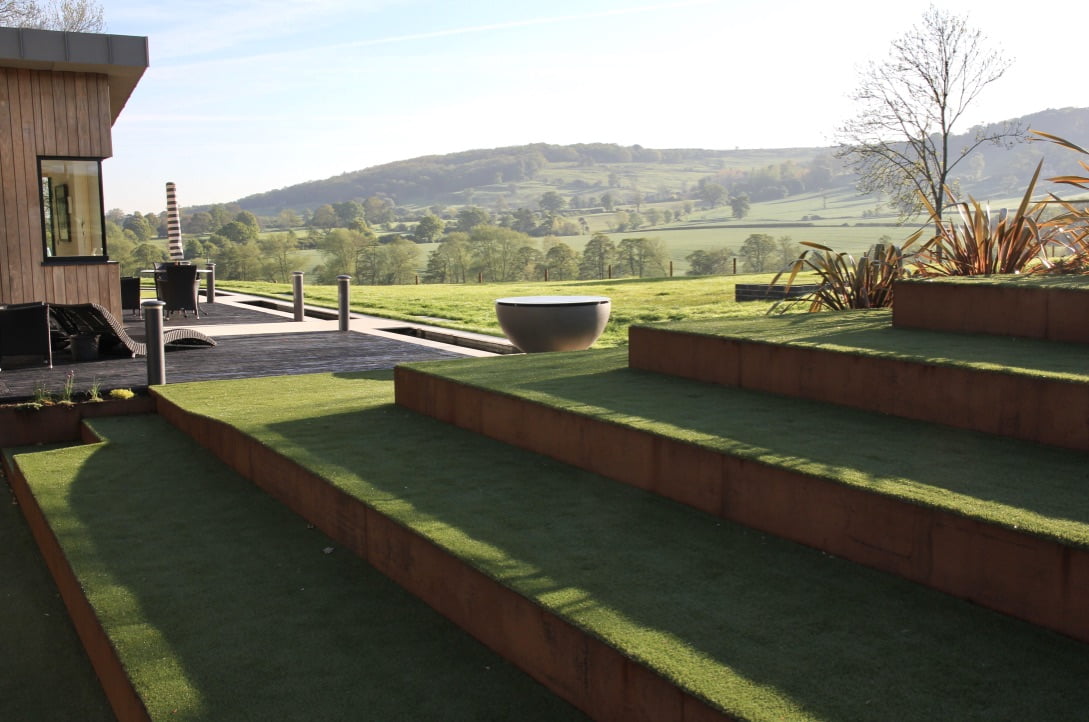 Corten steel steps & faux turf in this contemporary Cotswold scheme