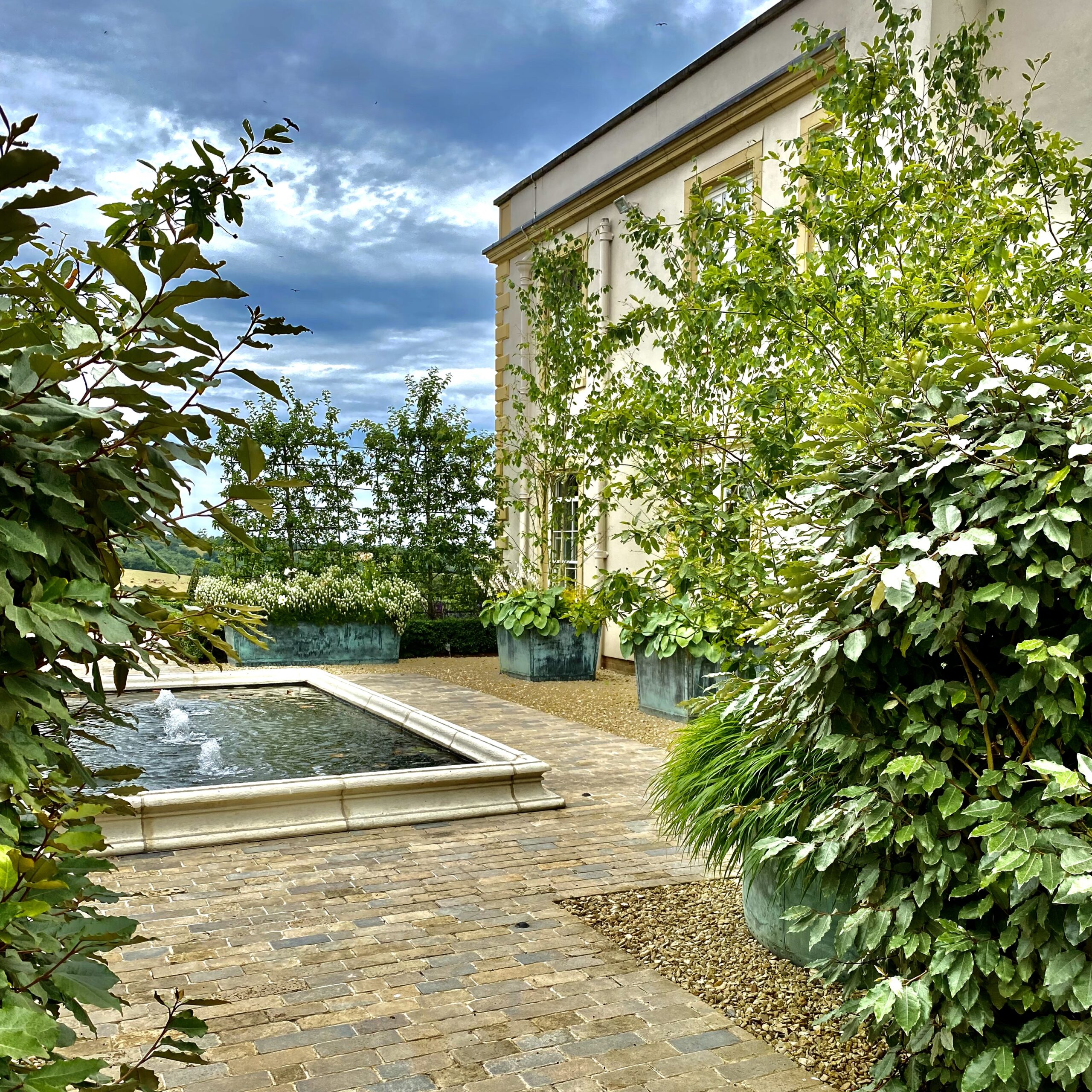 Courtyard design with fabulous stone pond beside Georgian house by Joanne Alderson Design